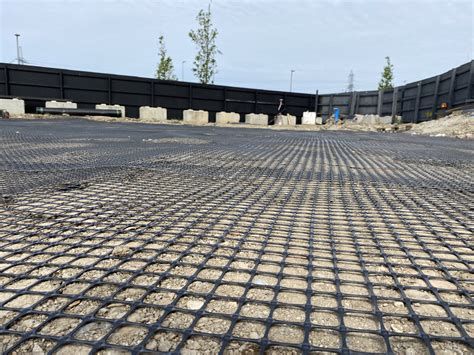 Close-up view of geogrid installation on a construction site, showcasing the mesh-like structure used for soil reinforcement and load distribution.